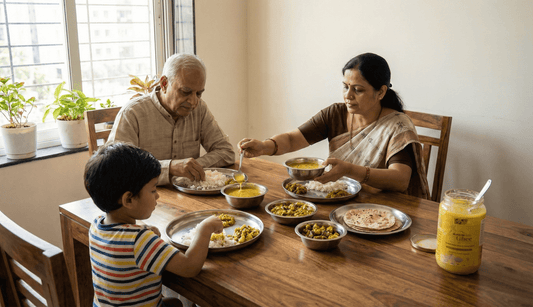 Indian family across three generations sharing a meal with a small amount of A2 ghee as part of everyday cooking